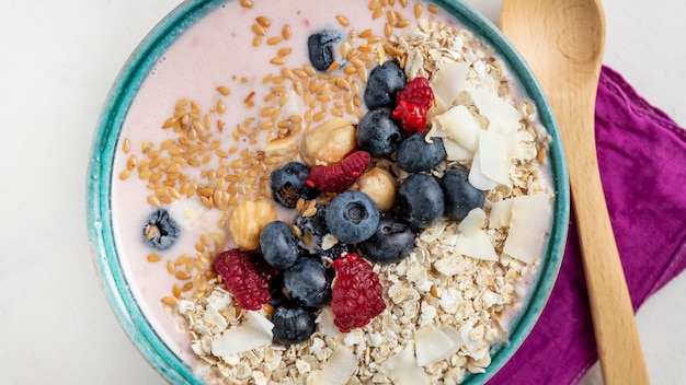 Top view of breakfast cereals in bowl with fruits and spoon