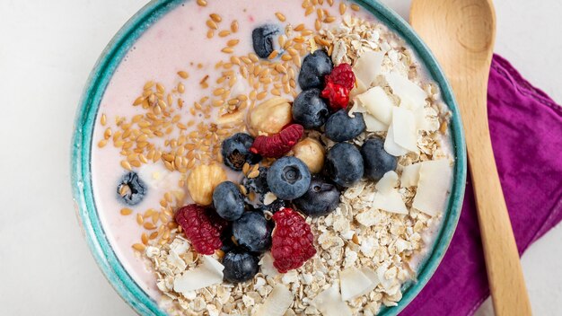 Top view of breakfast cereals in bowl with fruits and spoon