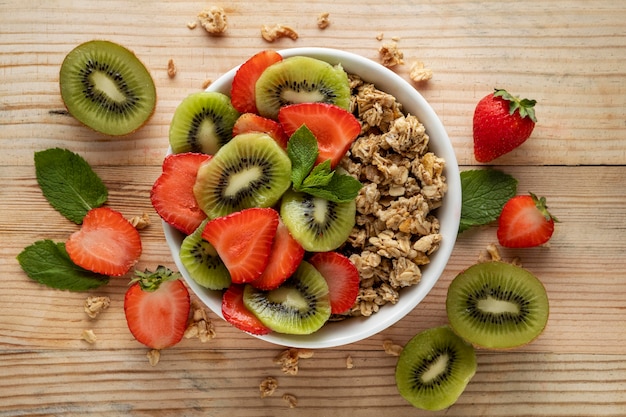 Top view of breakfast cereals in bowl with fruits