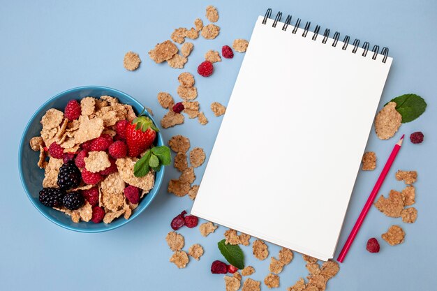 Top view of breakfast cereals with notebook