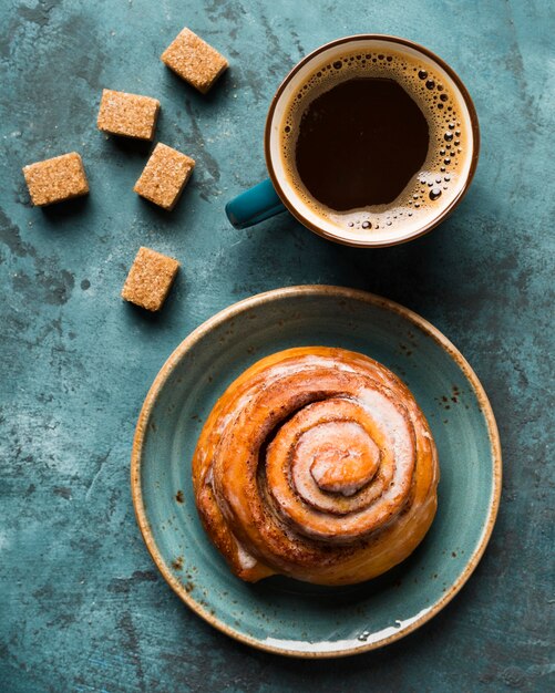 Top view breakfast composition with coffee and pastry