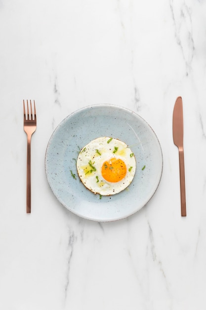 Top view of breakfast fried egg with cutlery