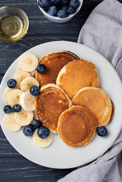 Top view of breakfast pancakes with blueberries and honey