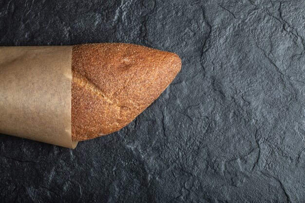 Top view of British baton loaf bread on black background.