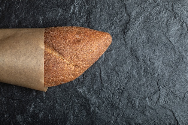 Top view of British baton loaf bread on black background.