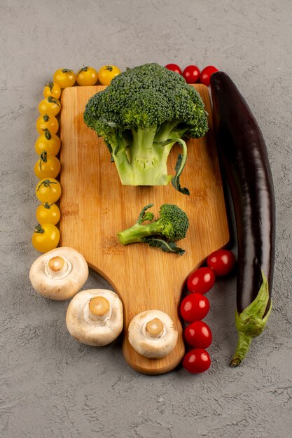 Vista dall'alto funghi broccoli pomodori freschi maturi sul grigio