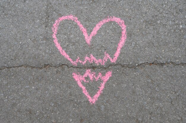 Top view of broken chalk heart on asphalt