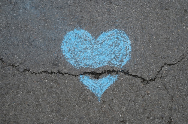 Top view of broken chalk heart on asphalt