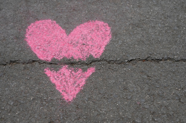 Top view of broken chalk heart on asphalt