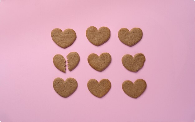 Top view broken cookie heart on pink background