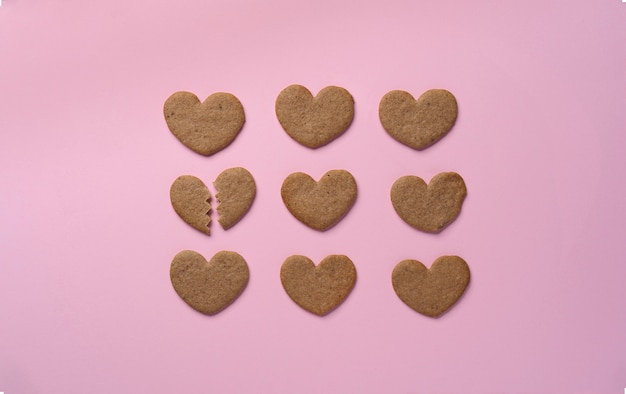 Top view broken cookie heart on pink background