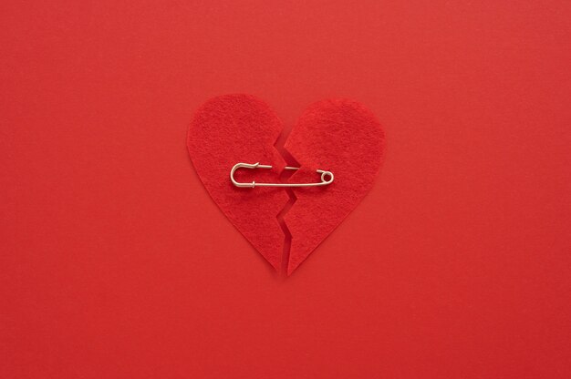 Top view of broken heart put back together with safety pin