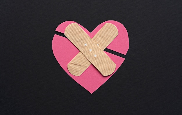 Free photo top view broken pink heart on dark background