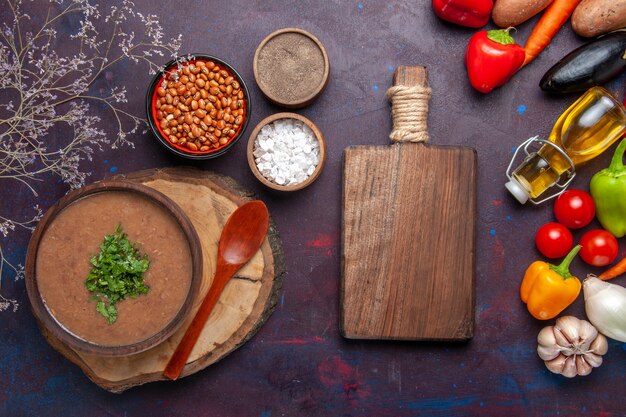 Top view brown bean soup delicious cooked soup with fresh vegetables on the dark surface soup bean color spicy meal