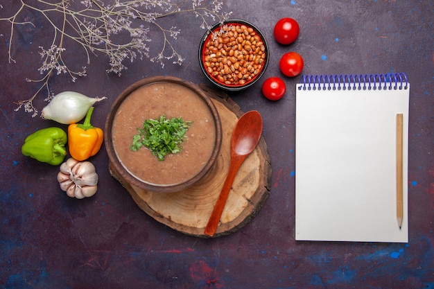 Vista dall'alto zuppa di fagioli marroni deliziosa zuppa cotta con verdure su cibo pasto pasto zuppa cena di superficie scura