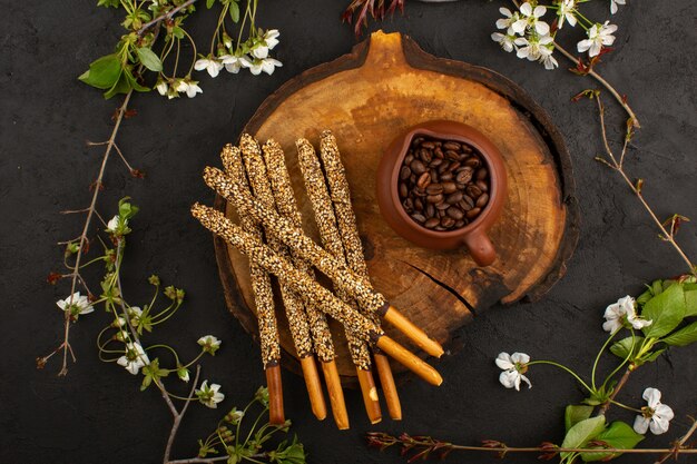 top view brown coffee seeds along with candy sticks on the dark floor