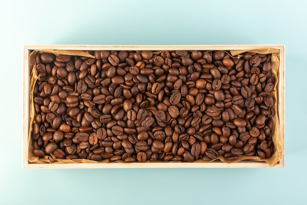 A top view brown coffee seeds inside box on the blue wall coffee cup photo seeds drink