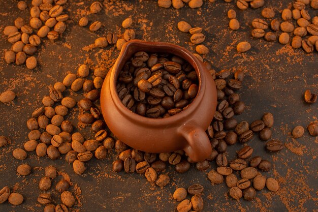 茶色の水差しの中と茶色のテーブル全体の上面の茶色のコーヒー種子