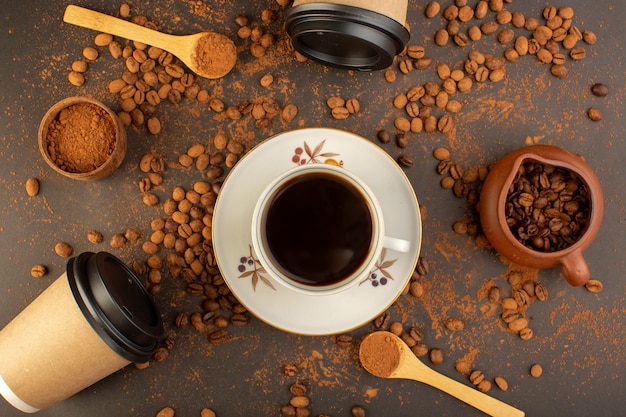 A top view brown coffee seeds with choco bars and cup of coffee