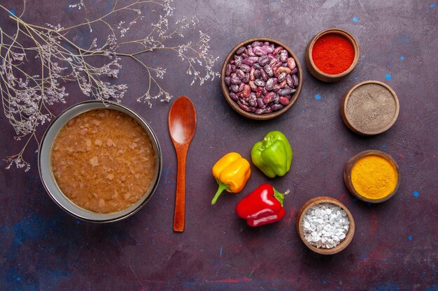 Top view brown soup inside plate with beans and seasonings on dark surface soup vegetable meal food kitchen oil