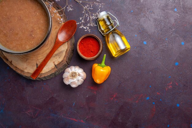 Top view brown soup with olive oil and garlic on dark surface soup vegetables meal food kitchen bean