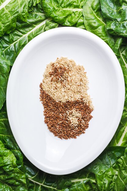 Top view of brown and white grains mixed in a white plate creating  ying and yang