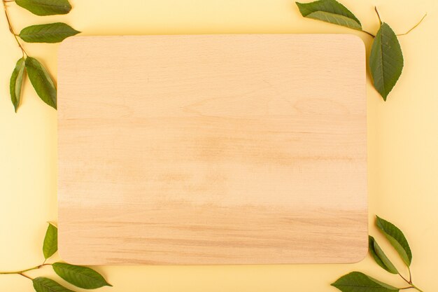 A top view brown wooden desk rustic along with green leaves apricot colored