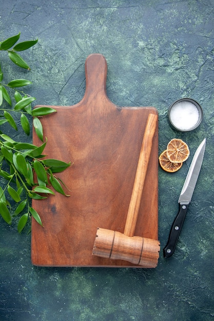 Top view brown wooden desk with hammer on the dark-blue surface color wood kitchen sharp brown cutlery tree spoon