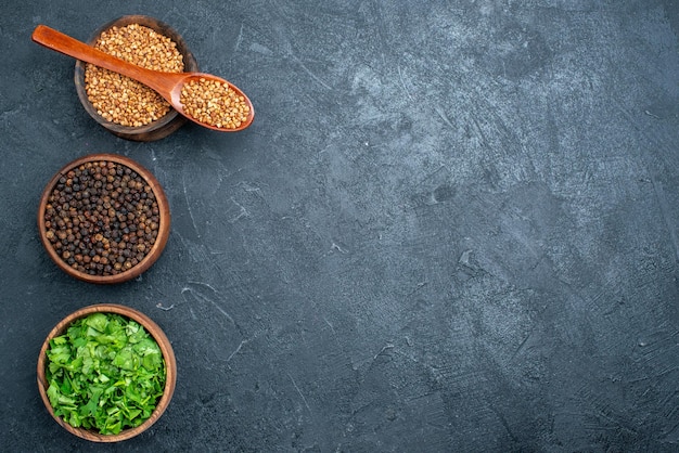 Top view buckwheat and greens with pepper on dark space