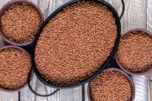 Top view buckwheat in pot and bowls o. horizontal