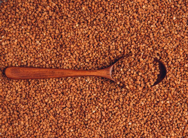 Top view buckwheats in wooden spoon. horizontal