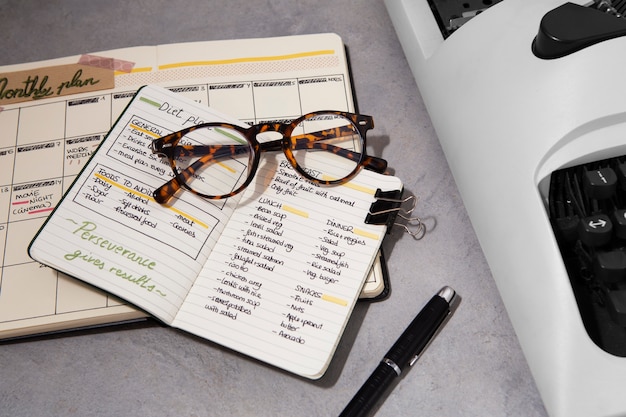 Free photo top view bullet journal and glasses