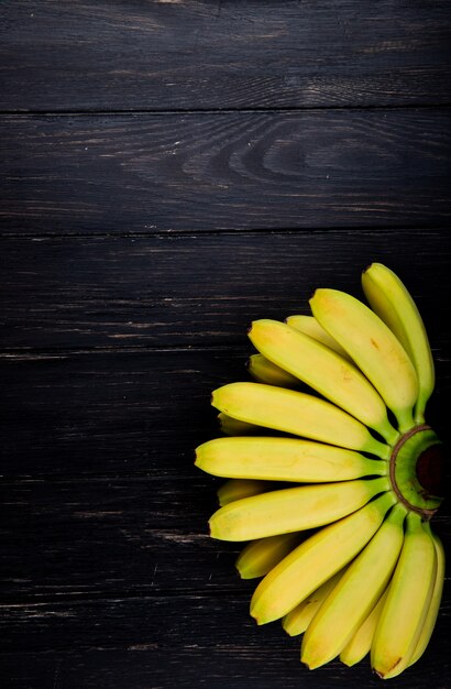 Top view of bunch of bananas on rustic wood with copy space
