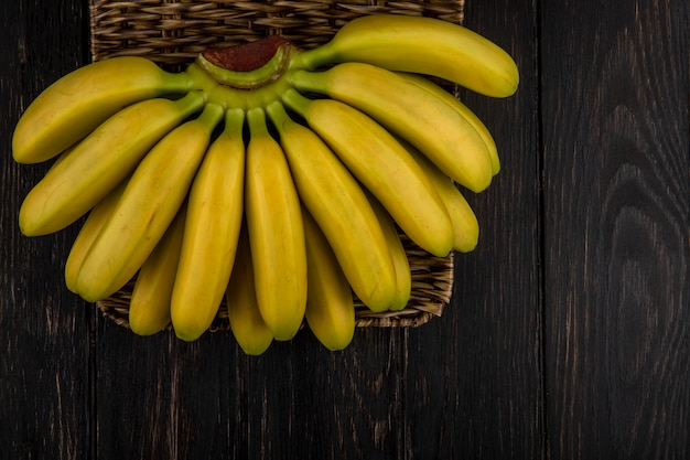 Top view of bunch of bananas in a wicker basket on dark