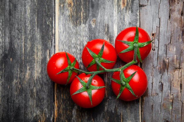 Top view a bunch of tomatoes on old wooden background. horizontal