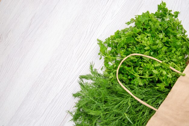 Top view of a bundle of green onion in a basket on the left side on white background