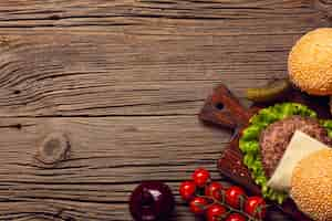 Free photo top view burger ingredients on wooden table