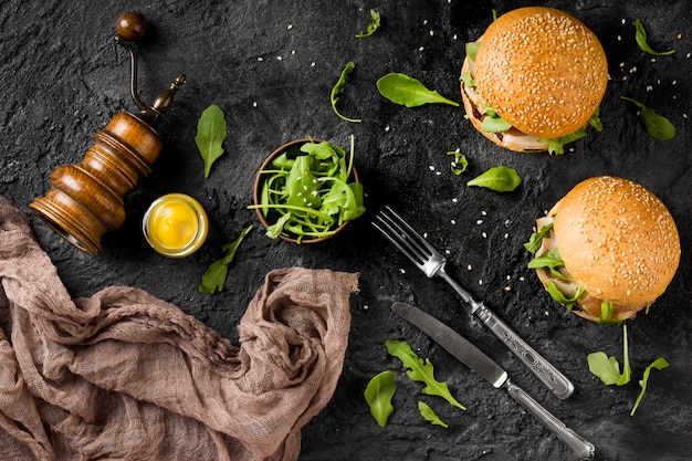 Top view burgers on counter with cutlery