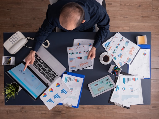 Top view of businessman pointing at financial statistics