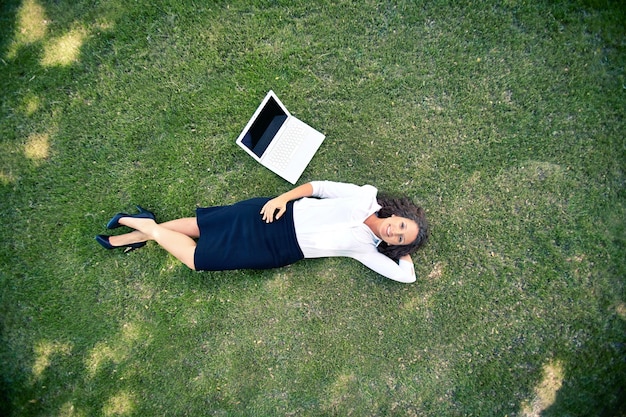 Free photo top view of businesswoman lying on grass