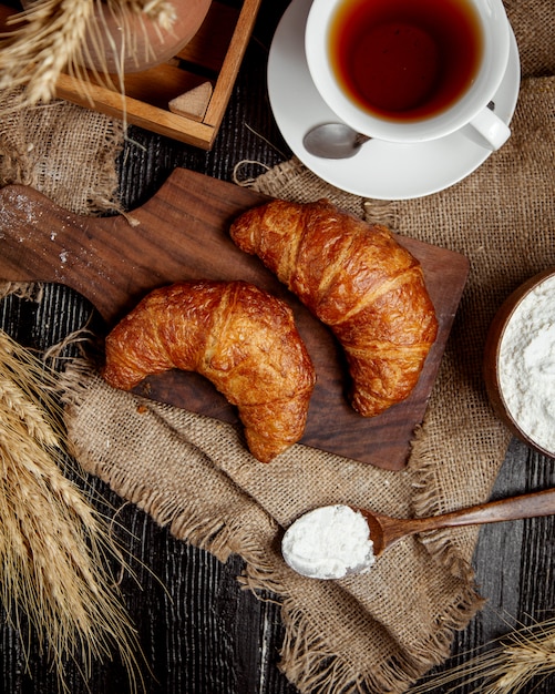 Top view of butter croissants places on wooden board