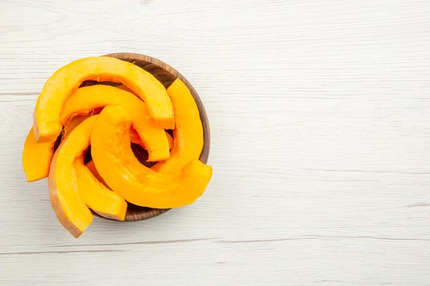 Top view butternut squash slices in bowls on grey table free space