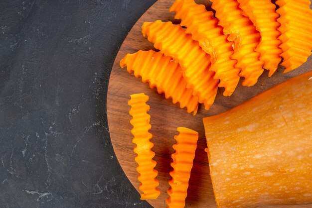 Free photo top view of butternut squash slices on wood board on table free space