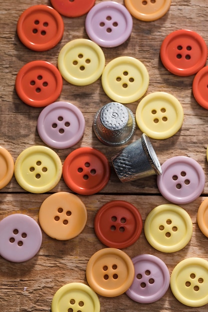 Free photo top view of buttons with thimbles on wooden surface