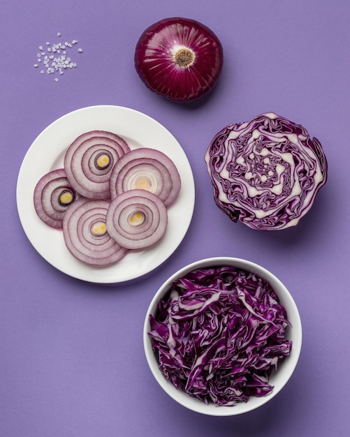 Top view of cabbage in bowl with onion on plate