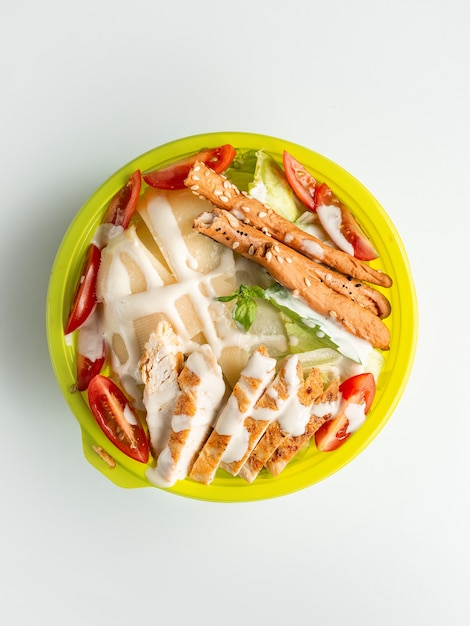 Top view of caesar salad with bread sticks in white background