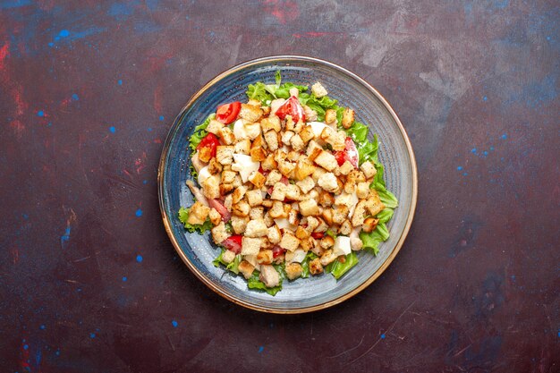 Top view caesar salad with sliced vegetables and rusks on dark desk vegetable salad food lunch meal rusk taste