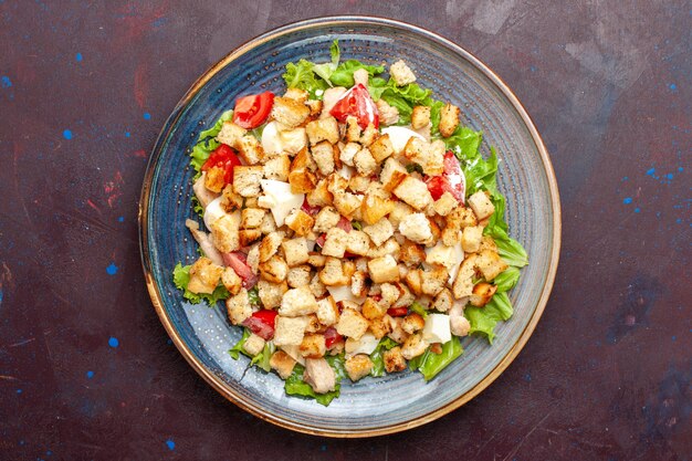 Top view caesar salad with sliced vegetables and rusks on dark wall vegetable salad food lunch meal rusk taste