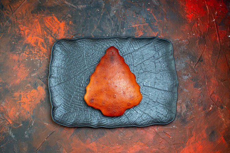 Free Photo top view cake on black platter on dark red table