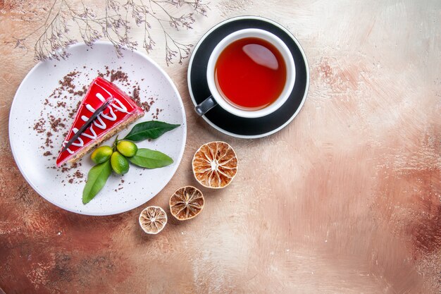 Top view a cake a cup of tea plate of cake dried lemon tree branches